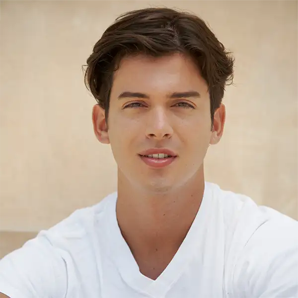 Young man with brown hair and blue eyes in a white t-shirt, headshot portrait